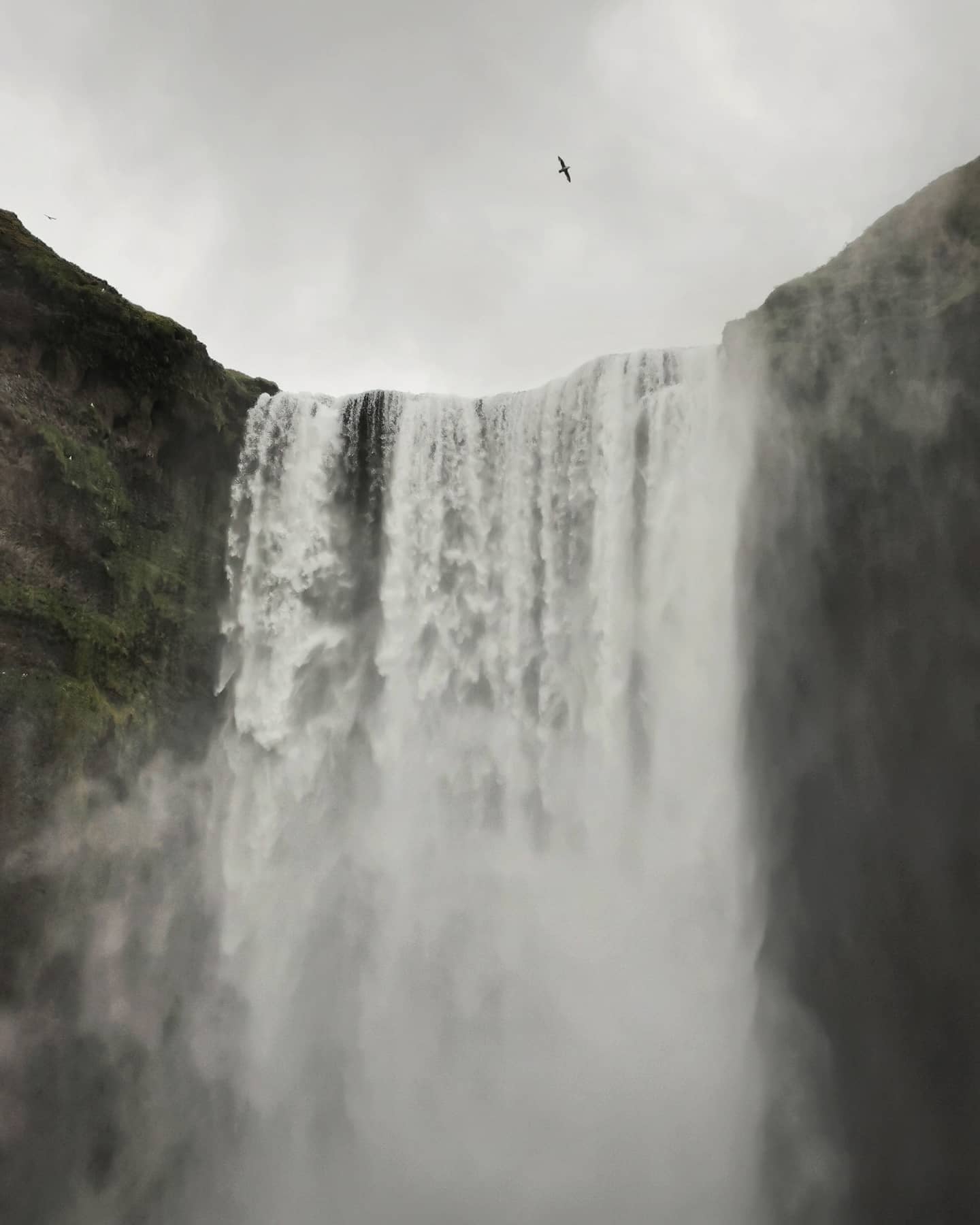 A wide waterfall pouring over a cliff edge