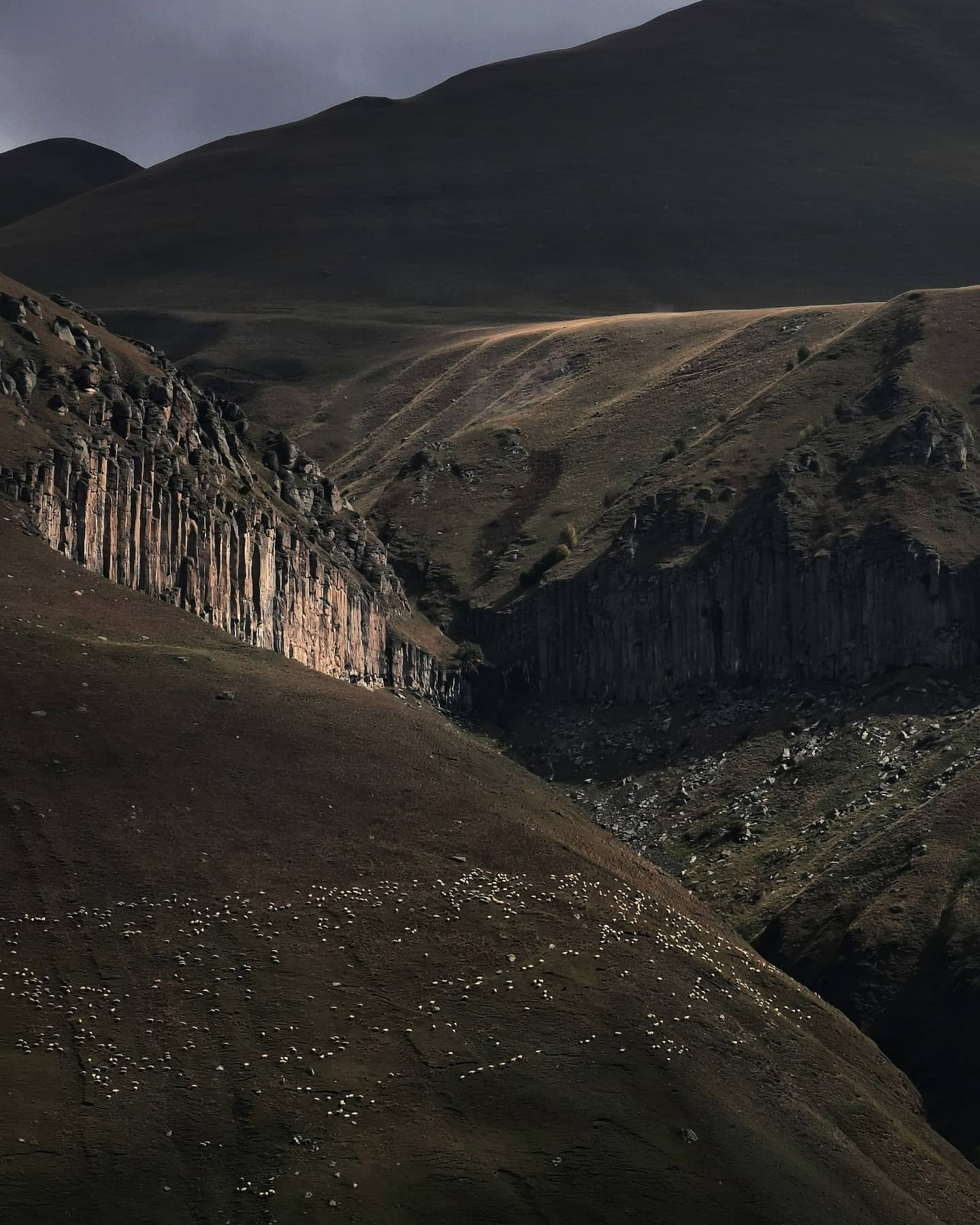 Basalt cliffs above a broad green valley