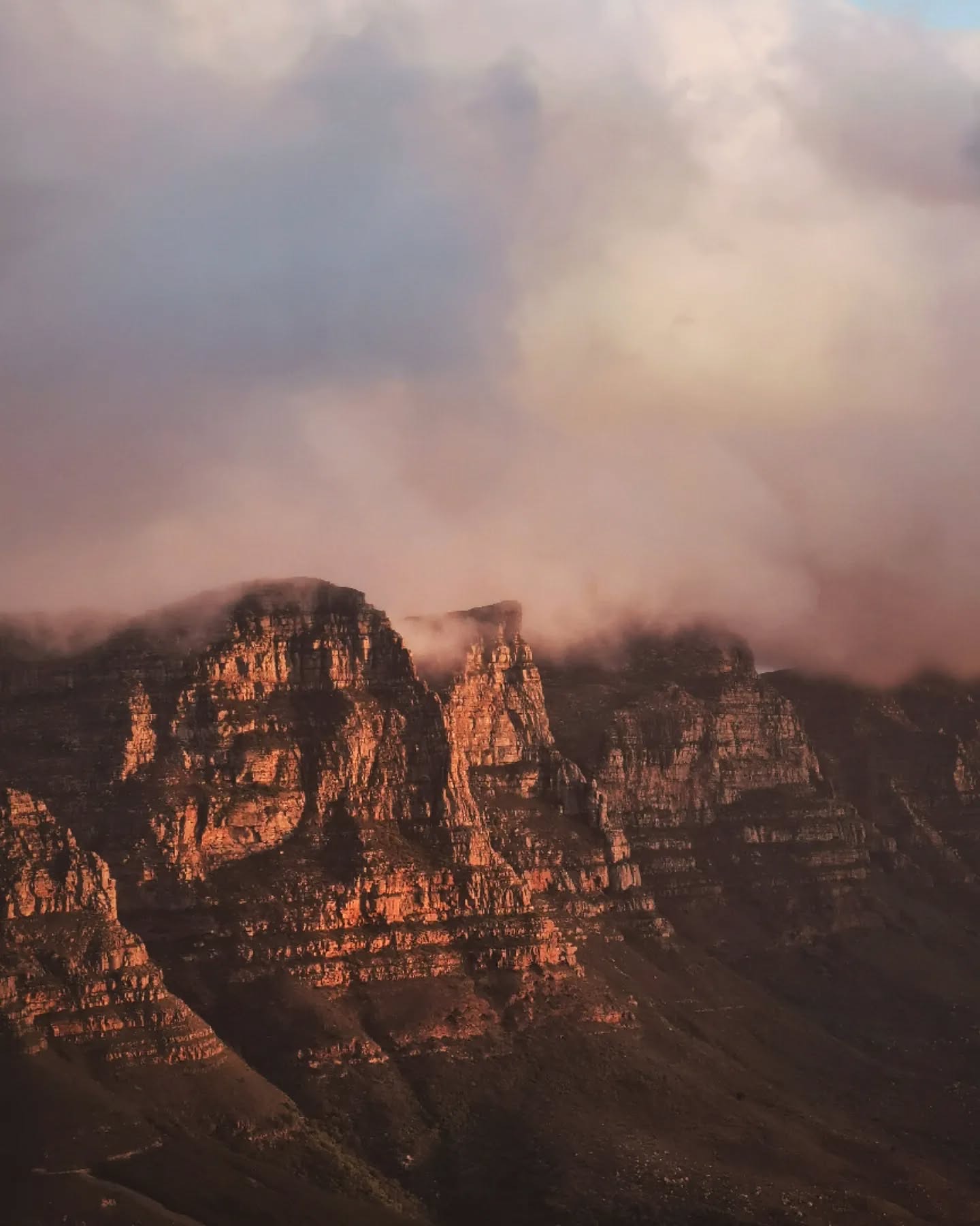 Red rock cliffs half-swallowed by low cloud