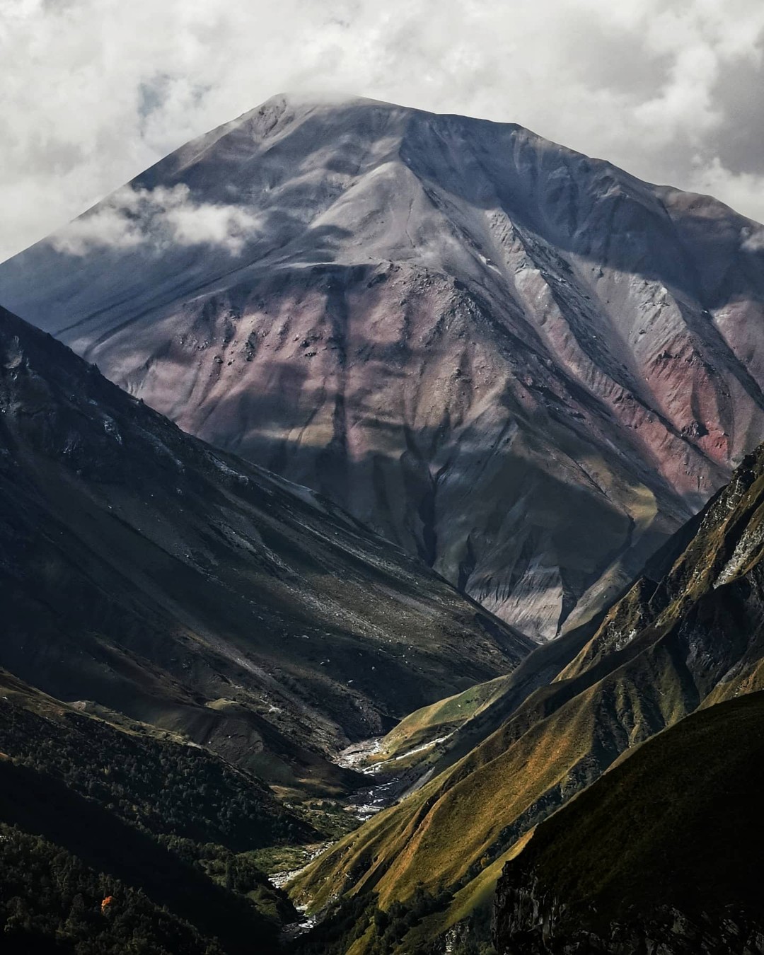 Layered mountain slopes in rust and green