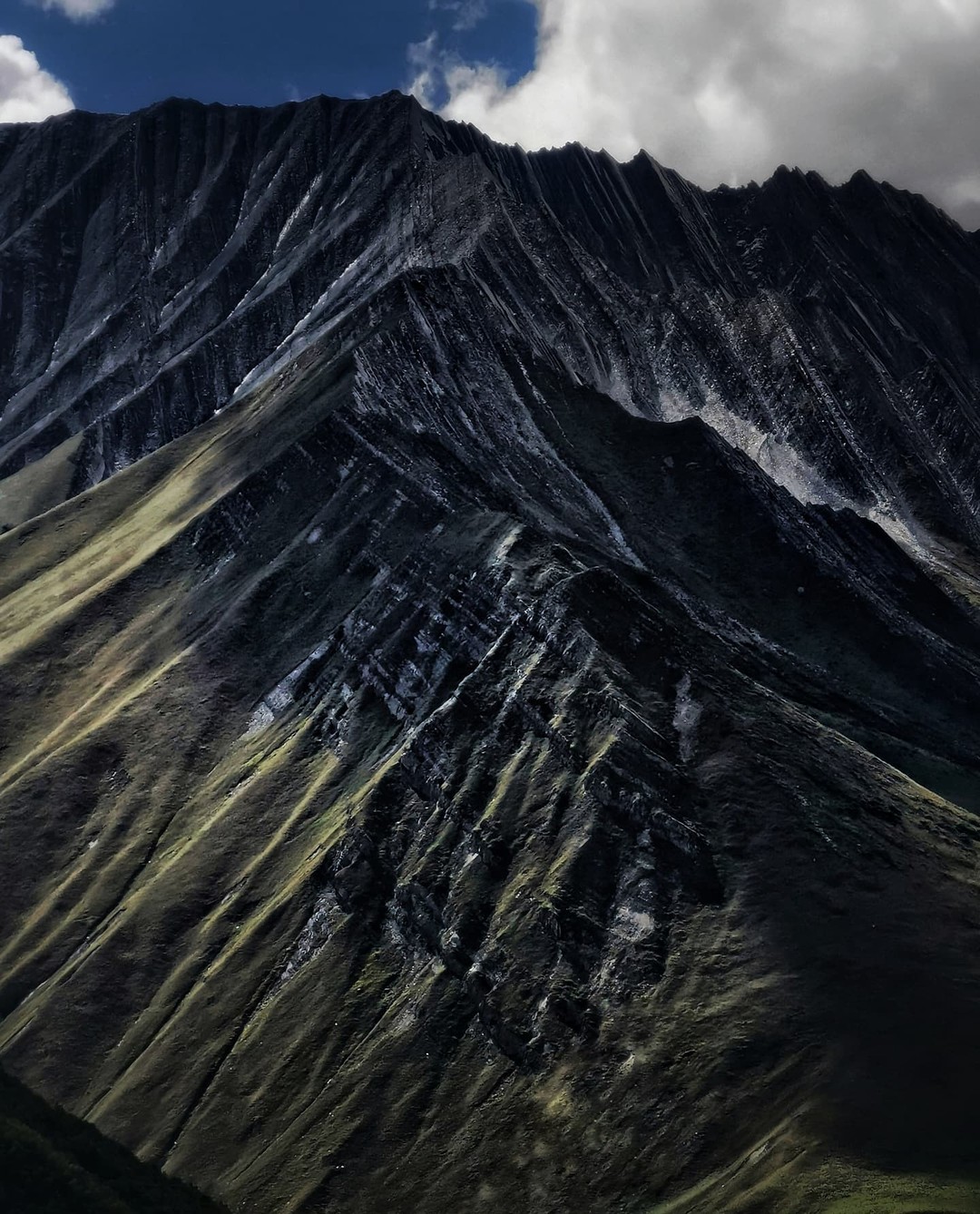 Steep dark ridges falling away in sharp folds