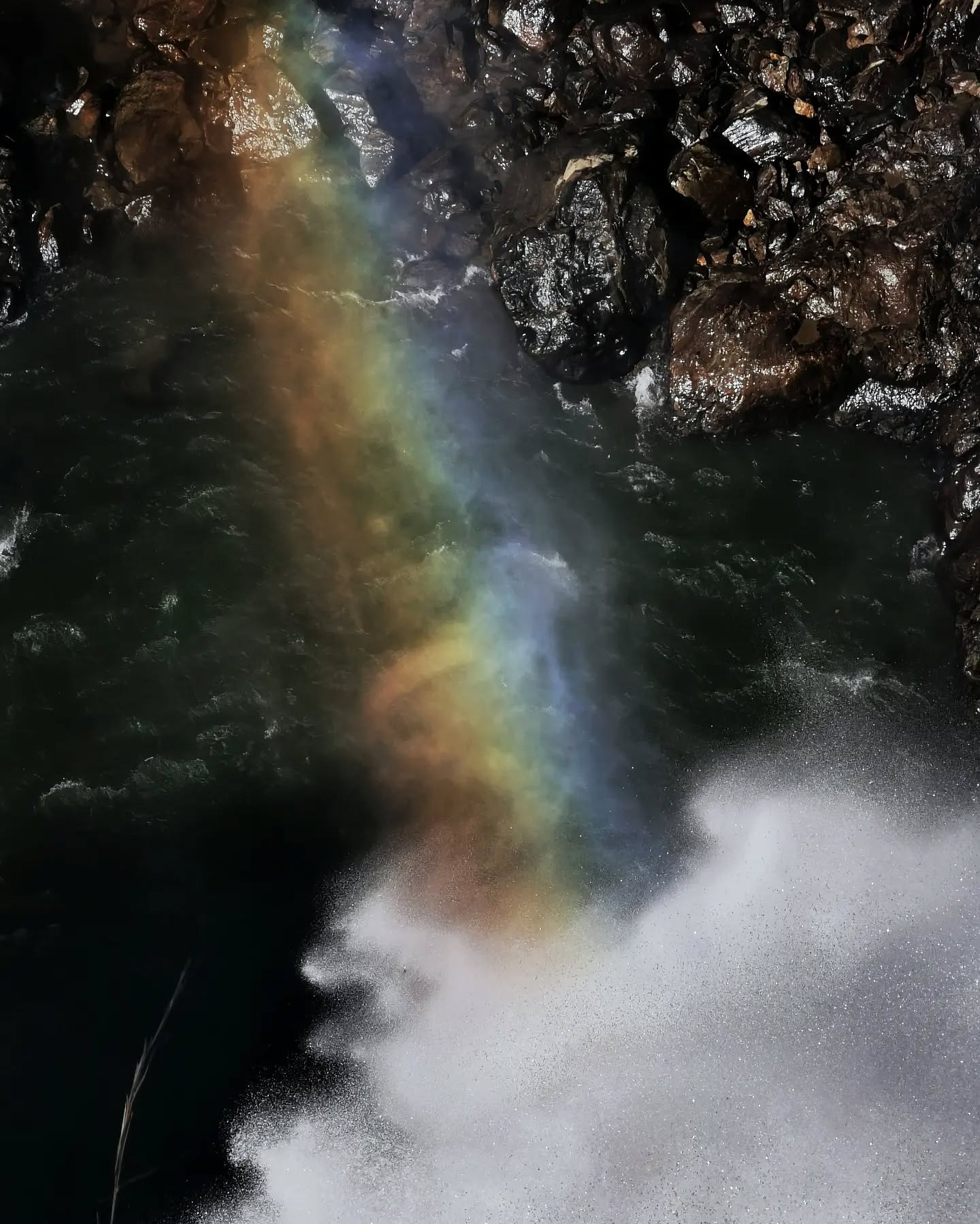 A rainbow forming in the spray of a waterfall
