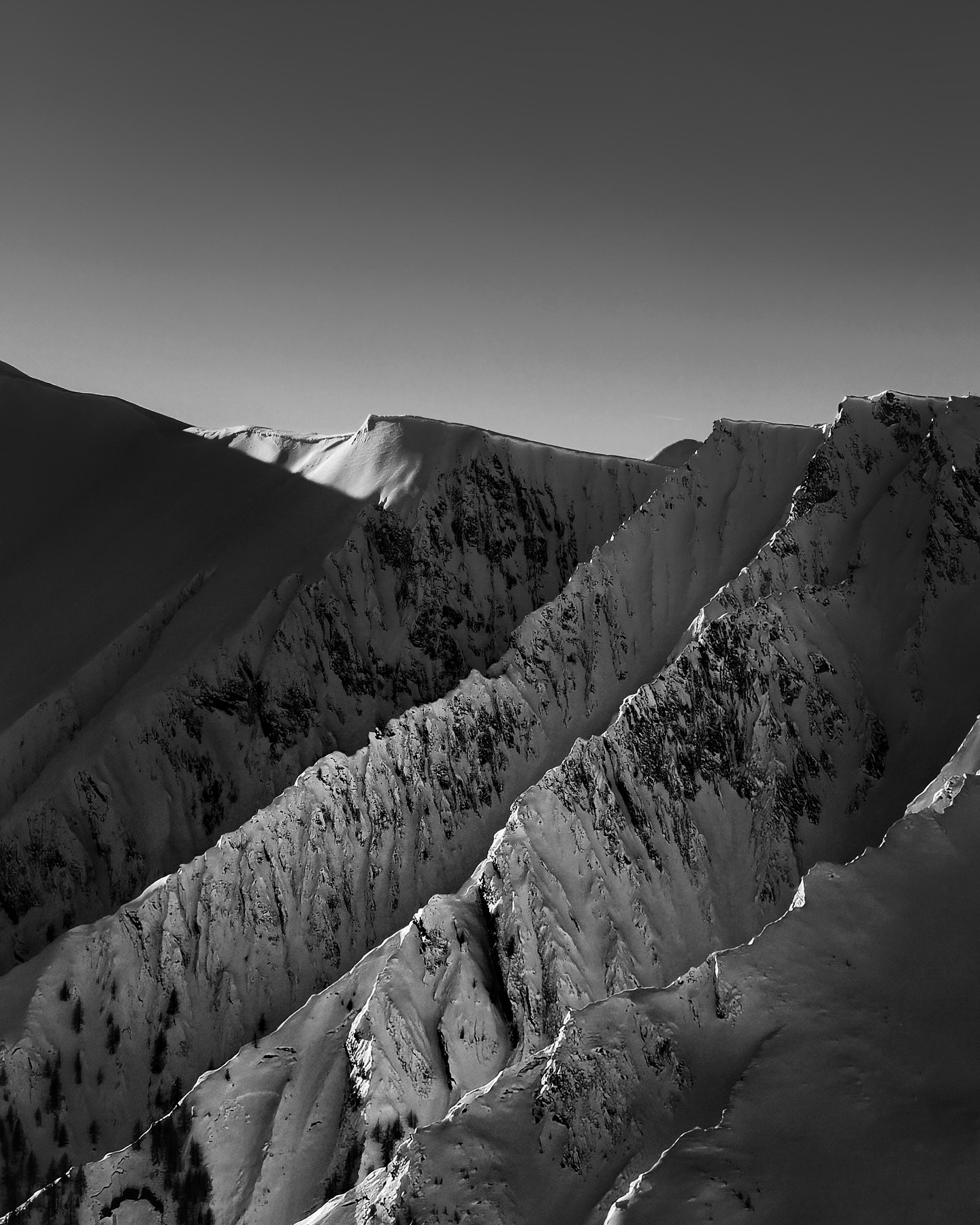 Snow-streaked mountain ridge in black and white