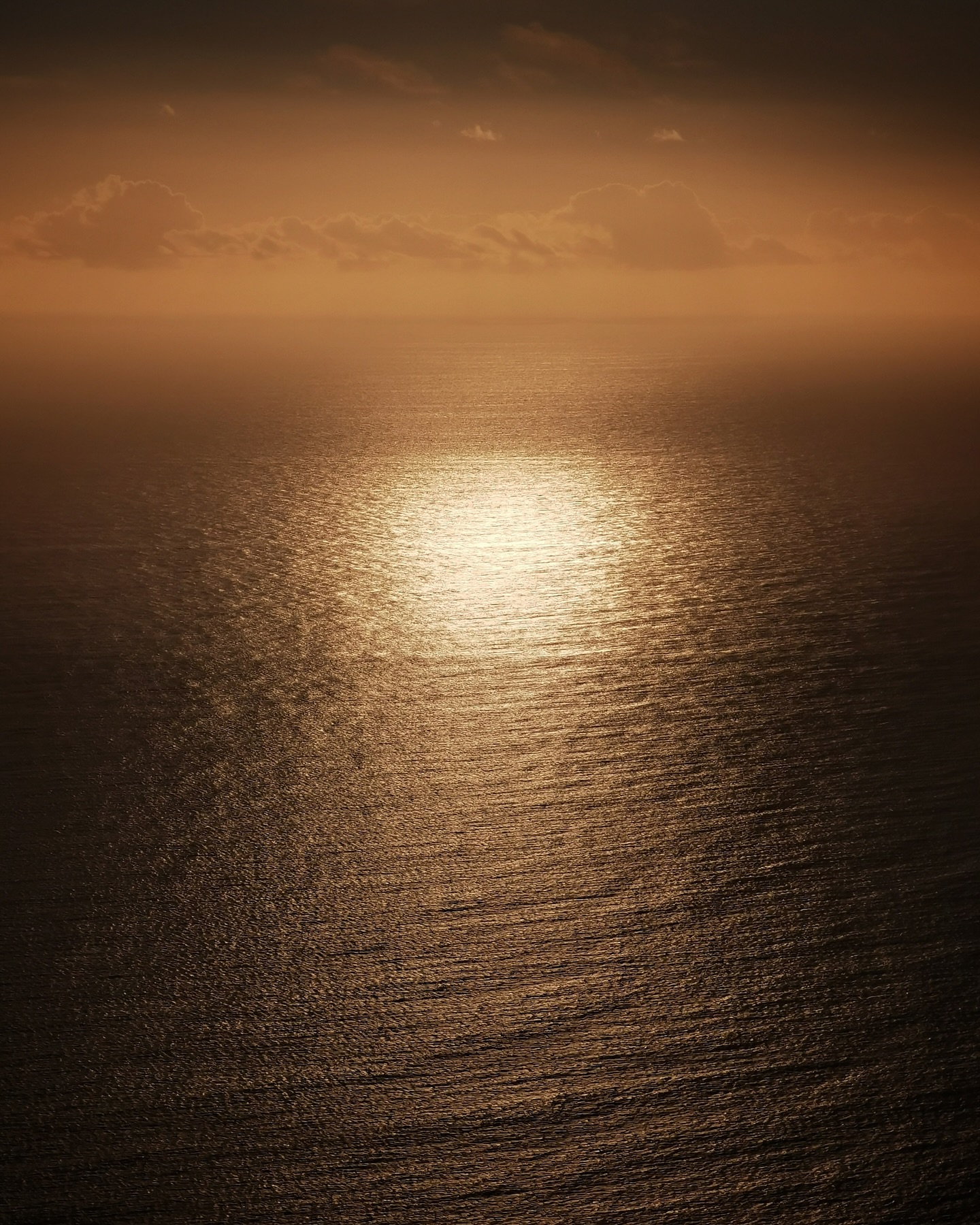 Sunlight scattering gold across a calm ocean at dusk