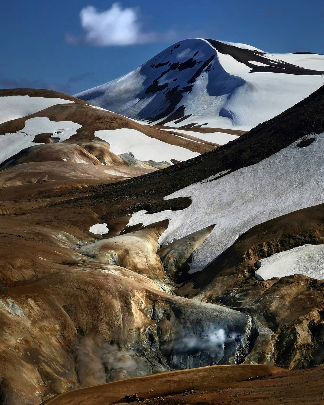 Snow-capped volcanic peak under a blue sky