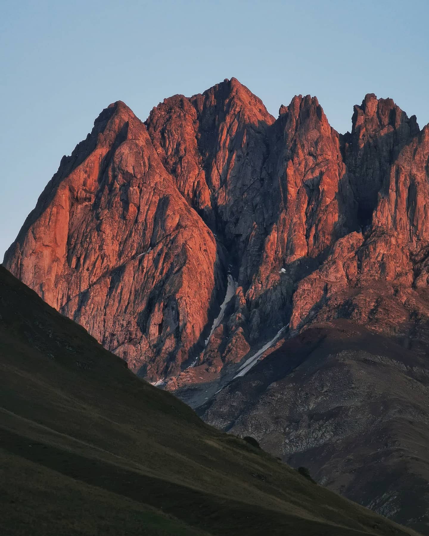 Jagged peaks lit red by low sun