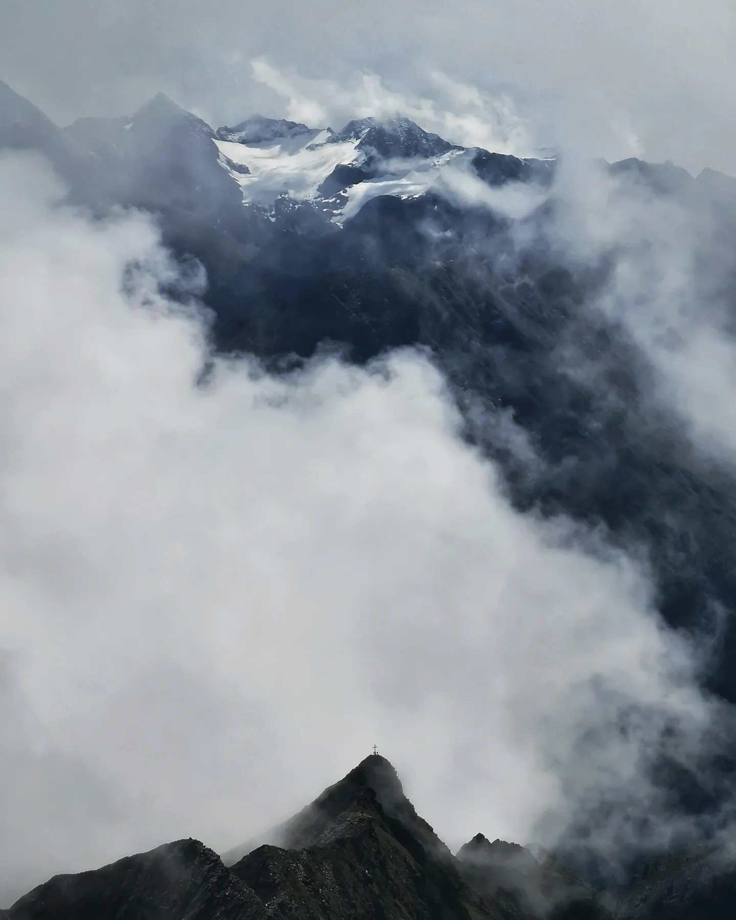 A dark peak breaking through a bank of cloud