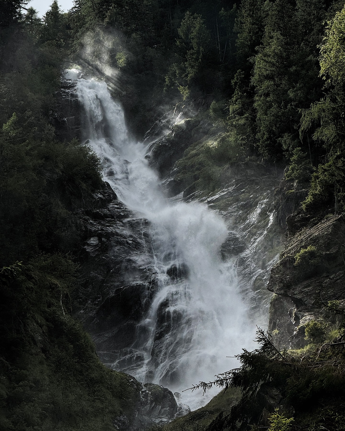 A waterfall falling through steep green jungle
